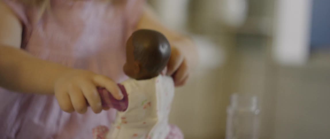 The child lifts up the doll moving it around