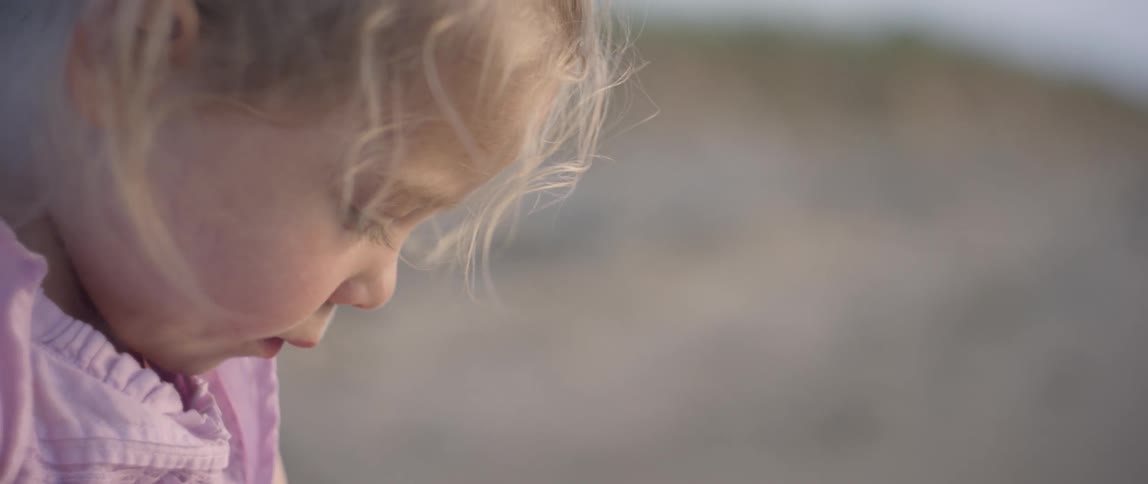 The child is playing on the beach