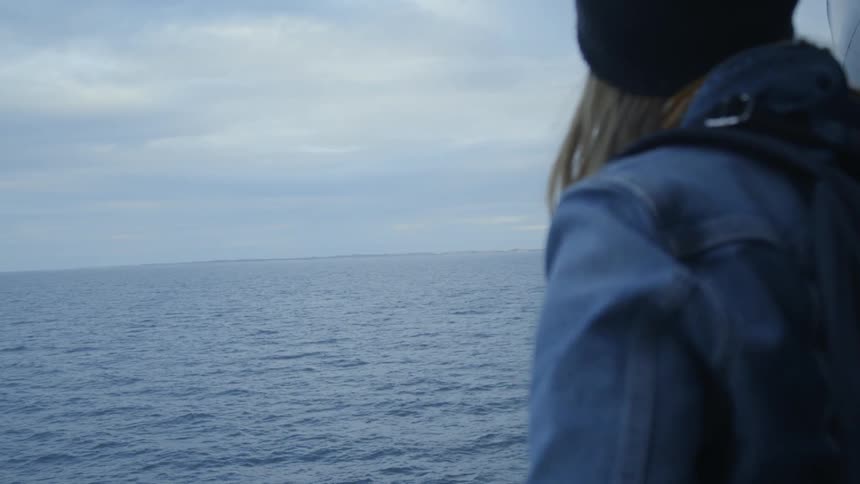 A woman rides on a ship at sea