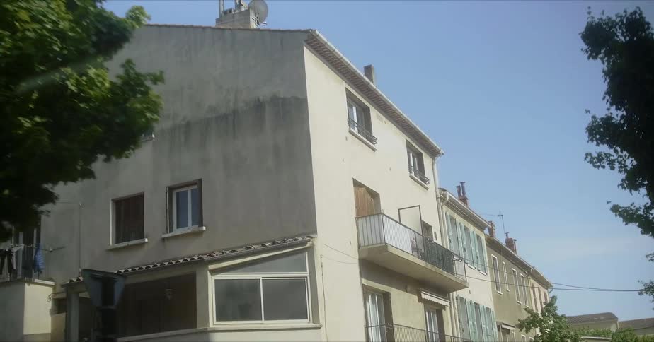 Passing city buildings and homes with balconies on a sunny day