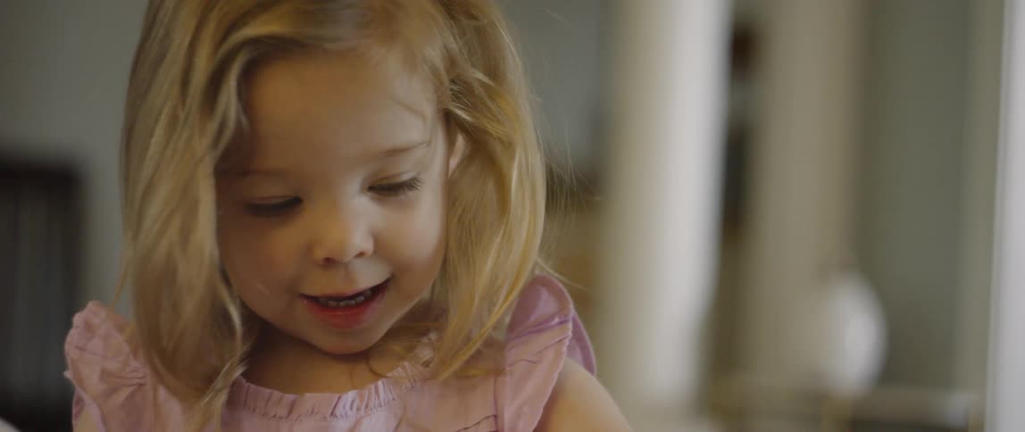 Young girl in a pink top and blond hair plays
