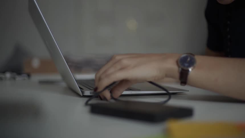 Woman connects a device to a laptop's usb connector