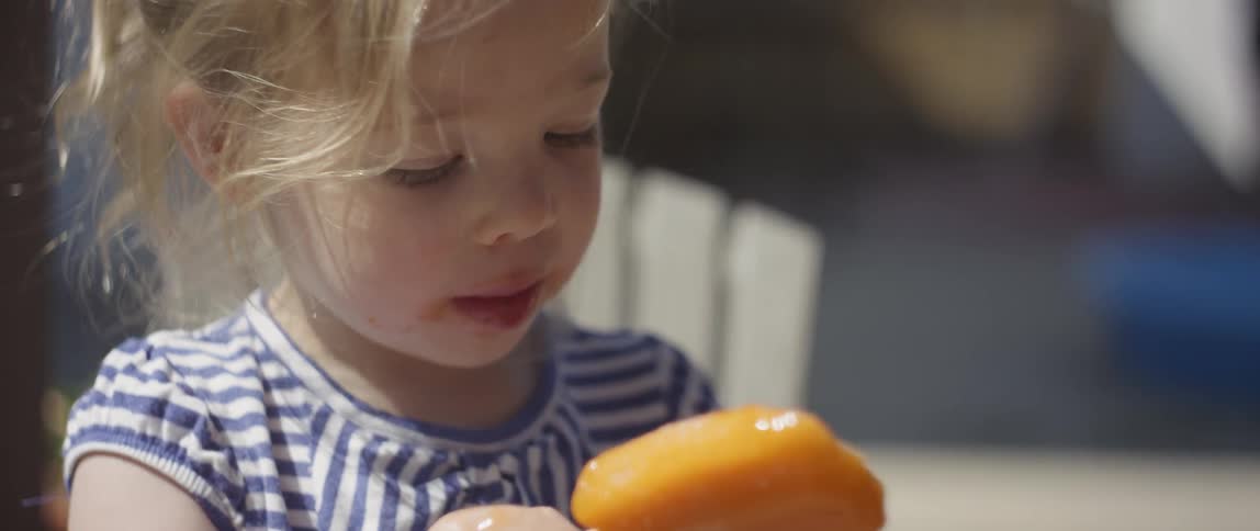 The child is eating an ice cream pop