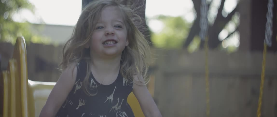 The girl laughs as she slides down
