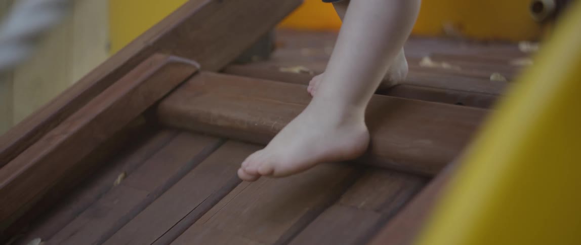 A young child climbs on a backyard toy