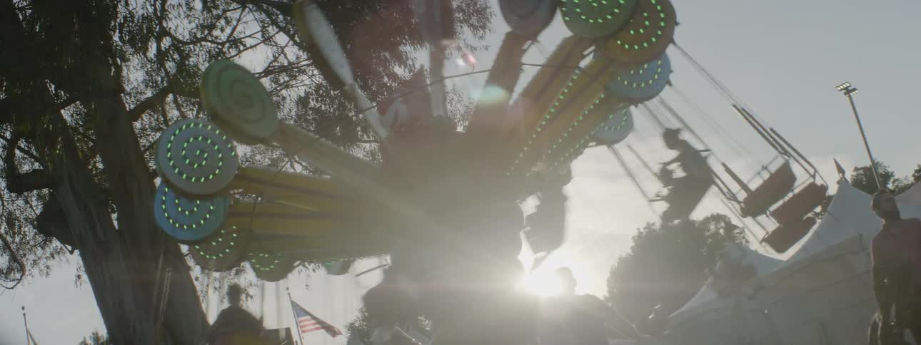 The carnival ride is swinging people in a circle