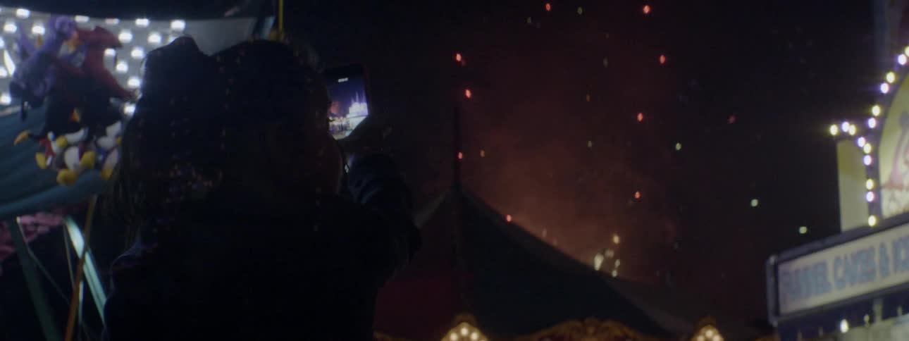Fireworks explode in the sky as people watch at night