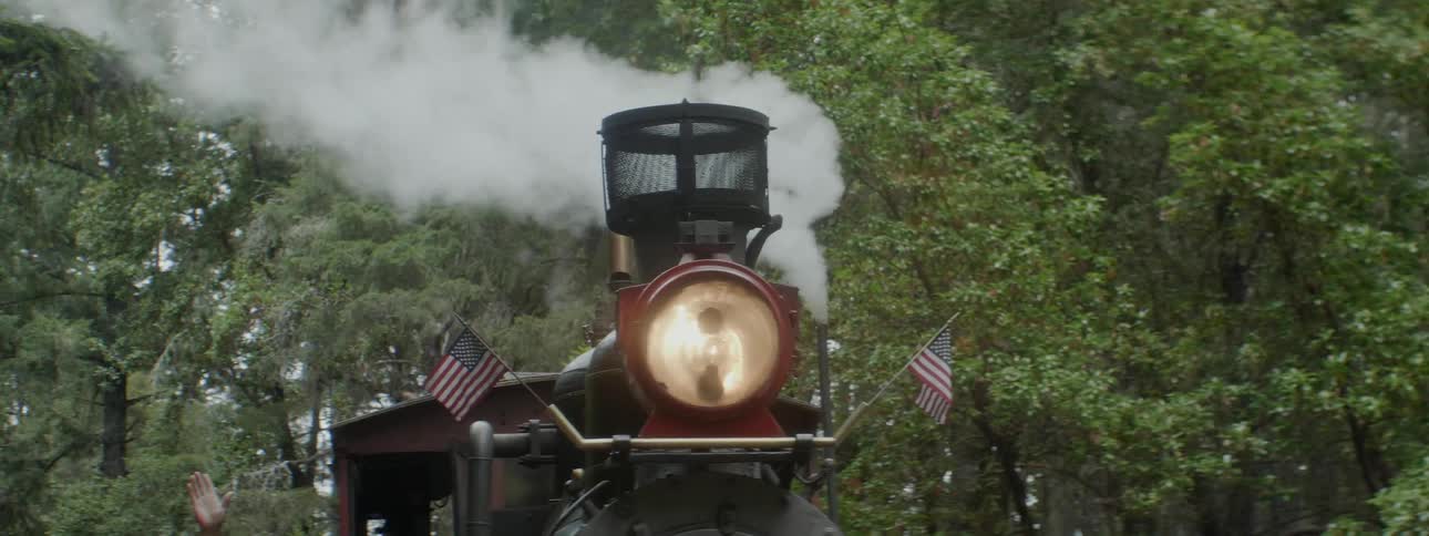 Steam billows from a steam engine with american flags
