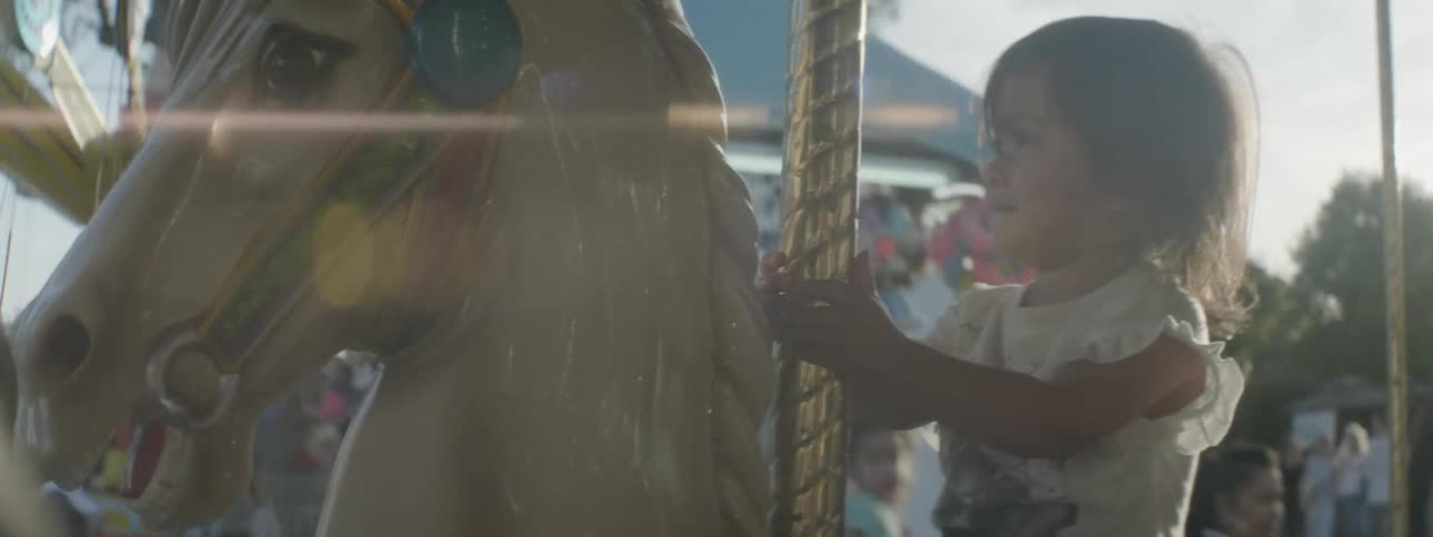 A child is riding the merry go round