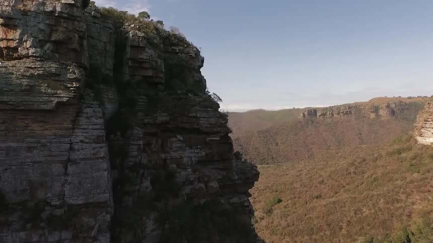 Aerial view of a steep cliff with a forest on the side