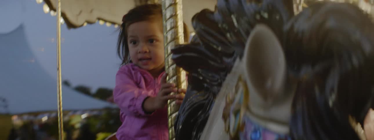 The child has fun riding on the merry go round