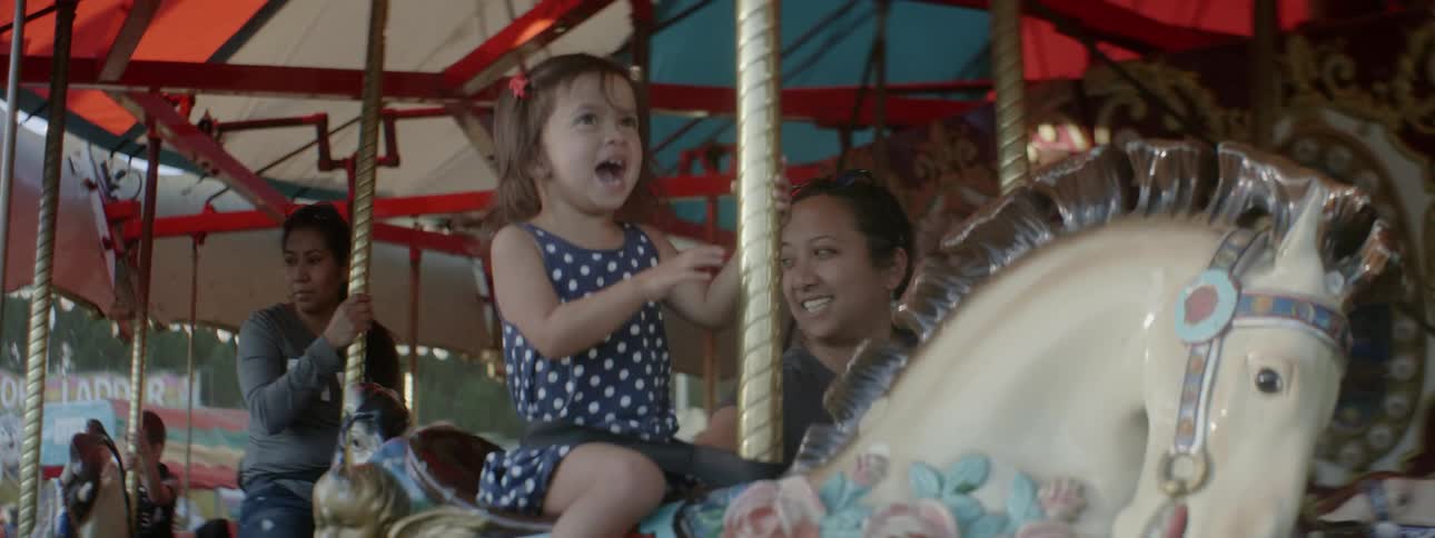 An excited girl screams while riding a carousel