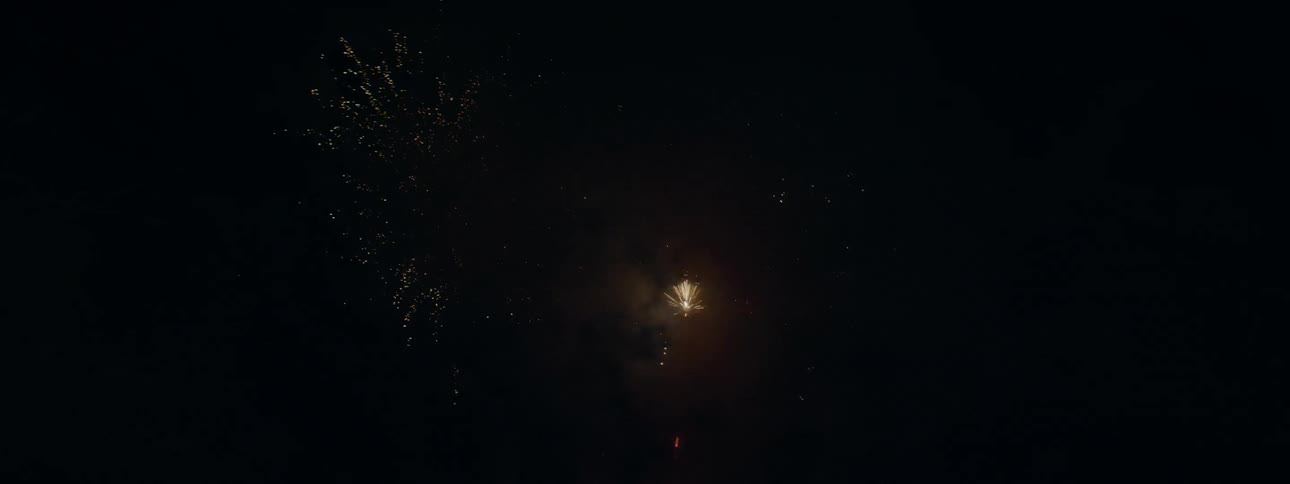 Fireworks explode into a cloud of smoke in the dark sky