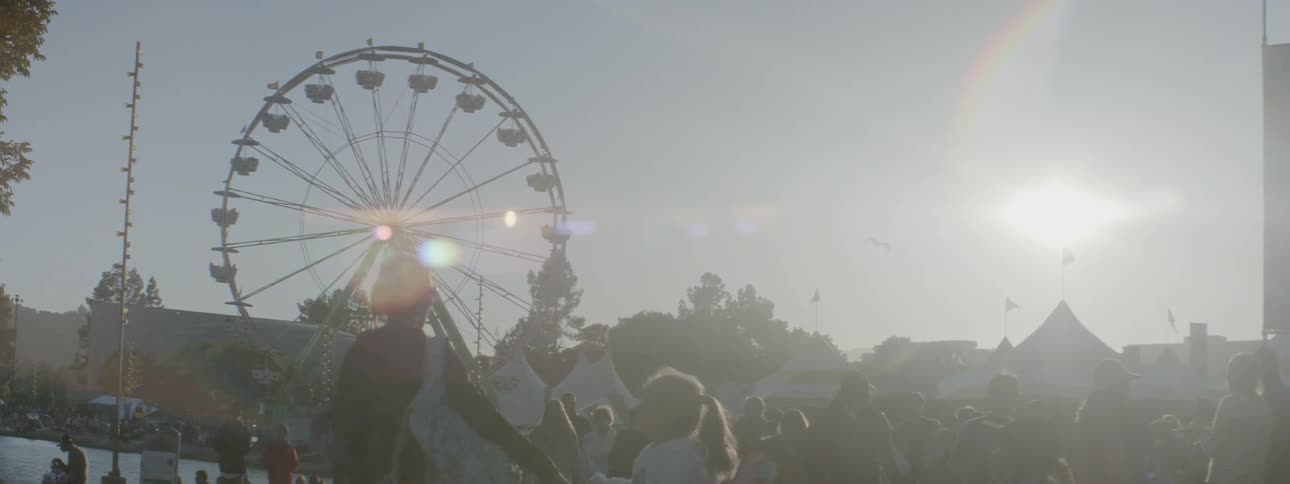 People walk around at a carnival on a sunny day
