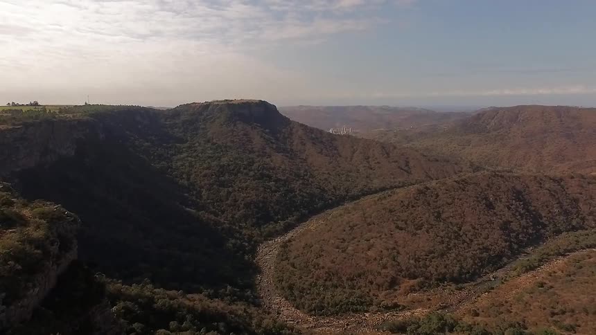 An aerial view of mountains and canyons on a semi-cloudy day