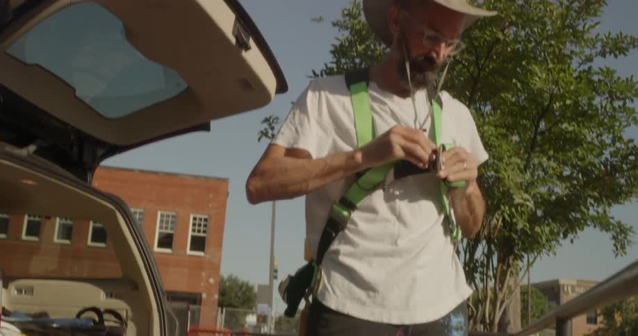 The man fastens a harness on by the vehicle