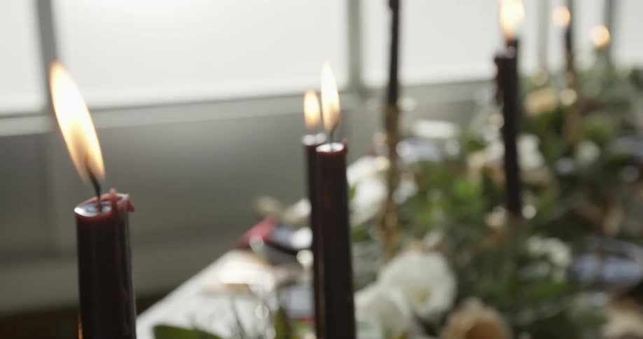 A number of candles lit on a banquet table