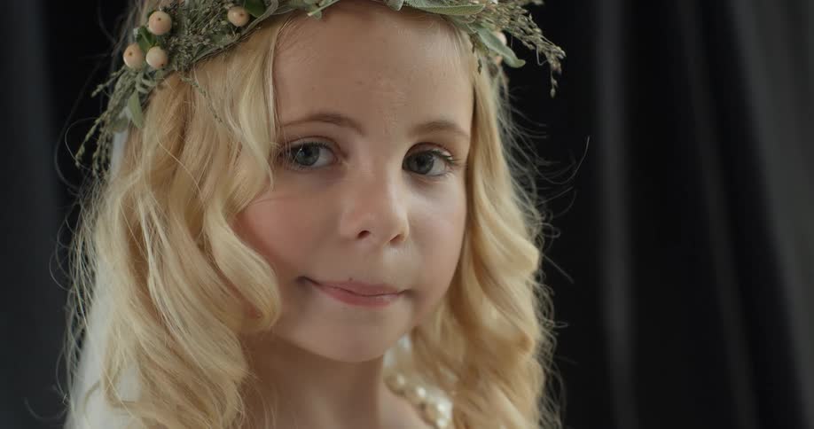 A young girl wears a flower wreath on her head