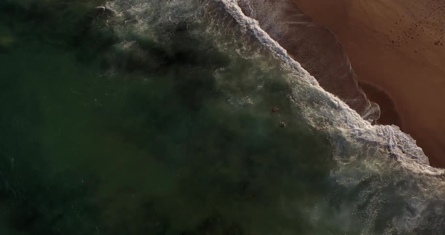 Aerial view of waves crashing on a sandy beach