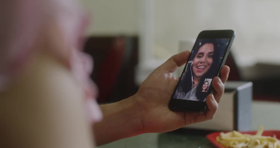 A woman smiles while making a video call