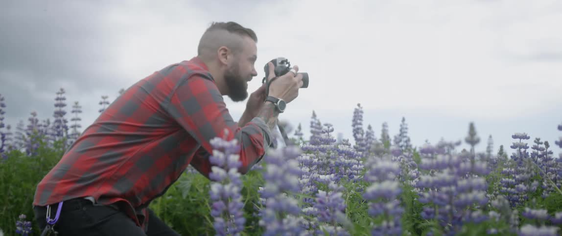 The man takes photos of the field full of flowers