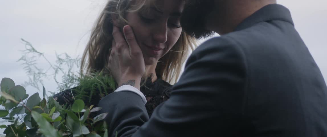 The man kisses the woman on the forehead