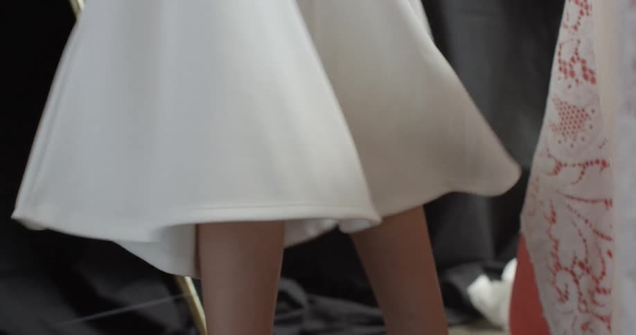 A white dress flows as a woman turns