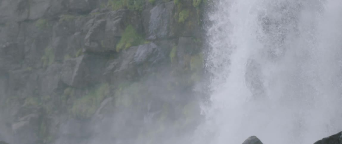 Water flows down over the rocks and splashes into the creek below