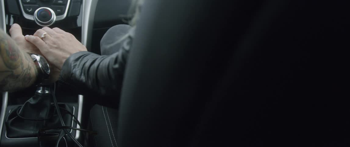 Woman riding in a vehicle holds the driver's hand
