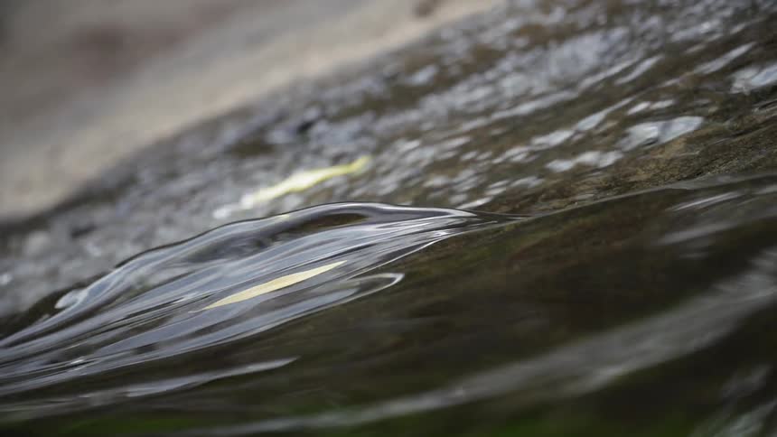 The water slowly moves downhill over the rocks