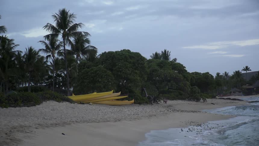 The waves move slow against the shore on a cloudy day