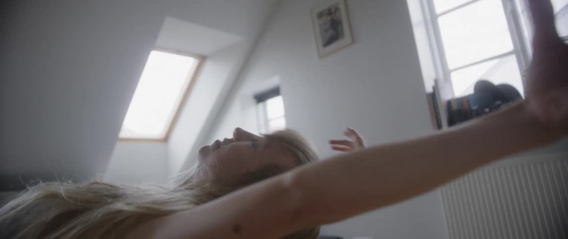 A woman dances and stretches in a living room