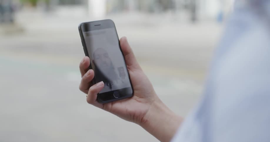 The person is holding their phone as they walk