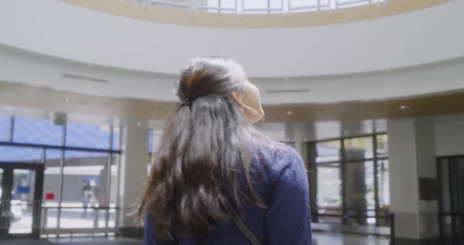 A woman carries luggage in an airport