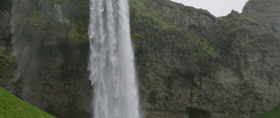 A waterfall flows over a cliff in the wilderness