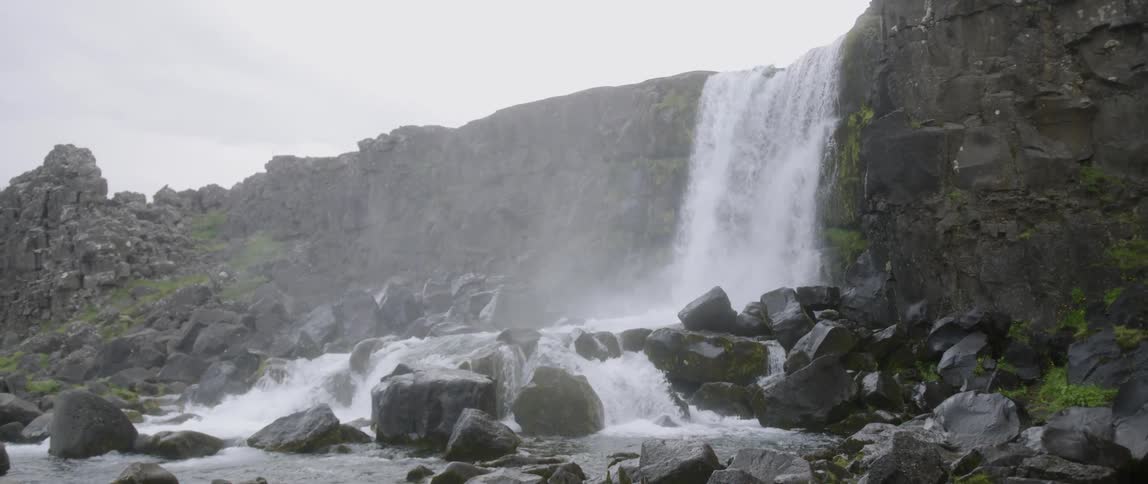 The waterfall is crashing onto the pile of rocks