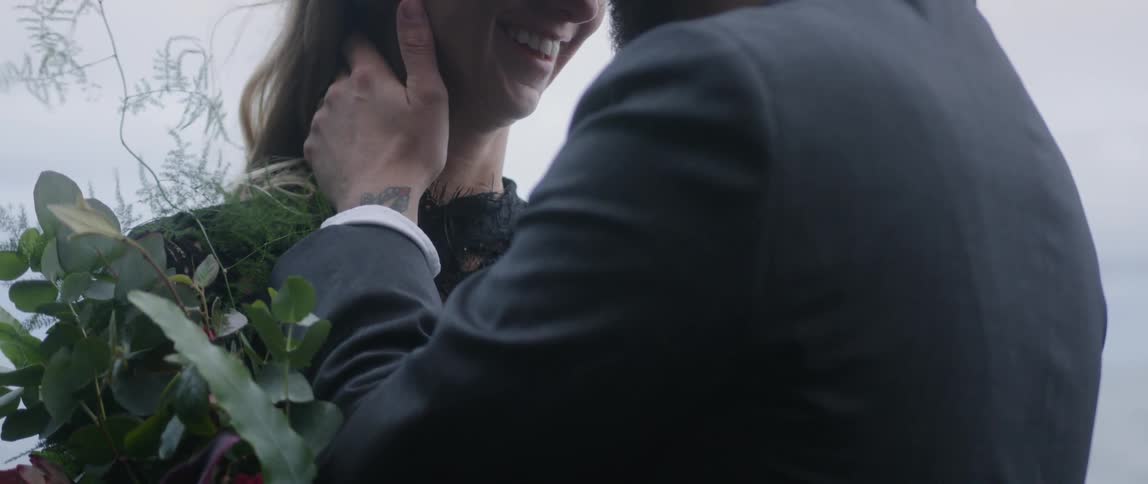 The man and woman kiss on a windy day
