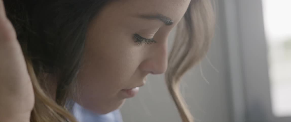 A woman brushes her hair back behind her ear
