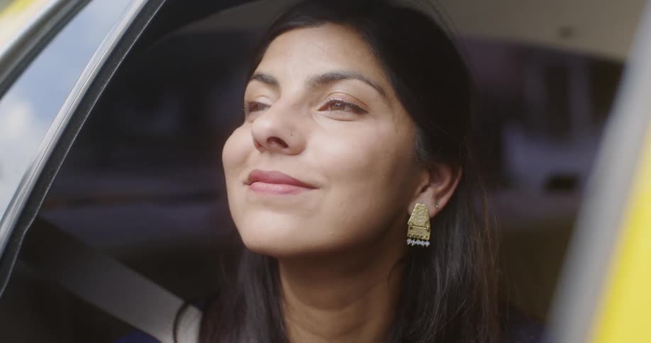 Woman looks out the open window as she travels in a vehicle