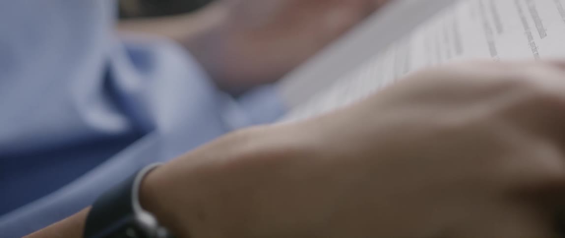 Person wearing a watch holds a book open