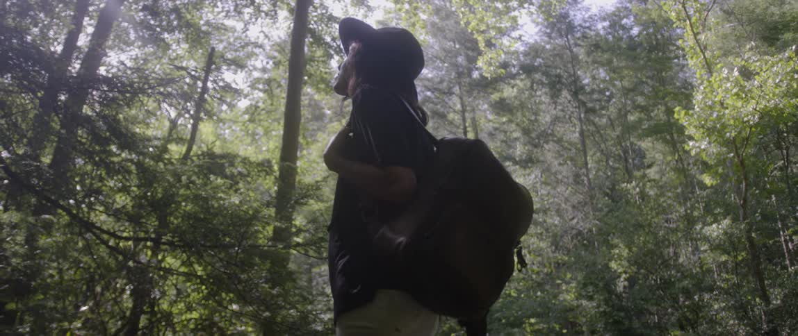 A woman looks around at the forest