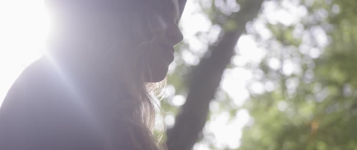 Woman walks outside in the woods on a sunny day