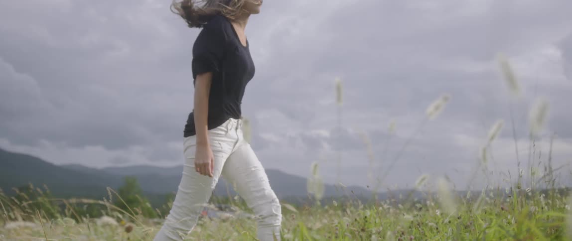 A woman walks through the tall grass