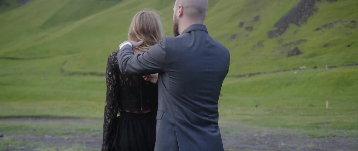 The man zips up the woman's dress