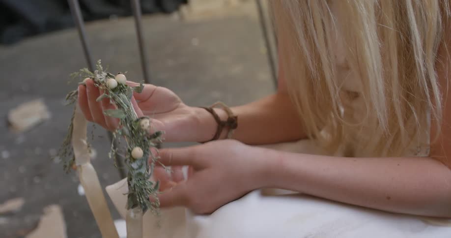 A woman with blonde hair holds a headpiece for examination
