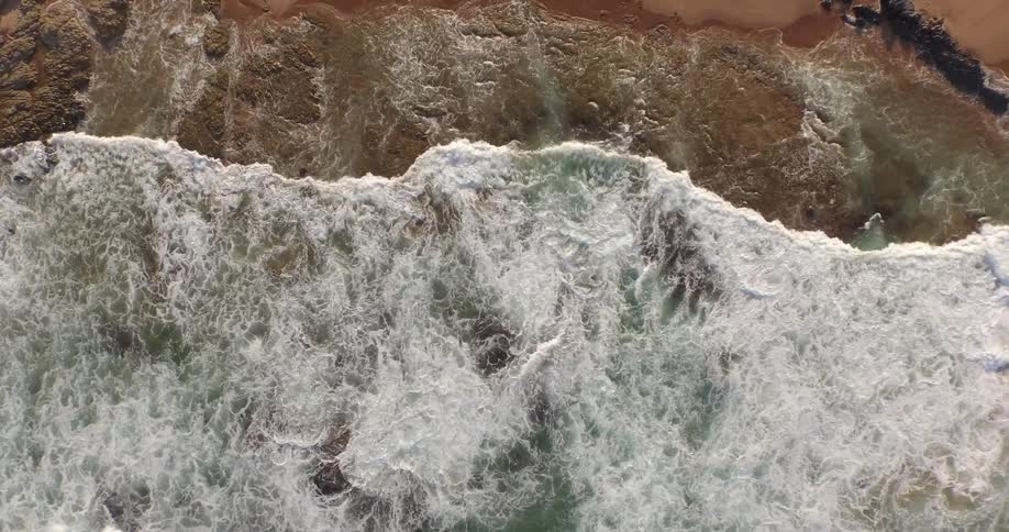 Large waves crash on a rocky shore