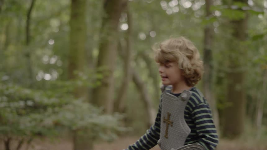 A young boy runs outside while dressed up as a knight