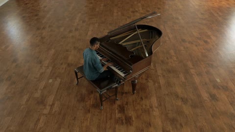 A man is sitting at a piano and playing it