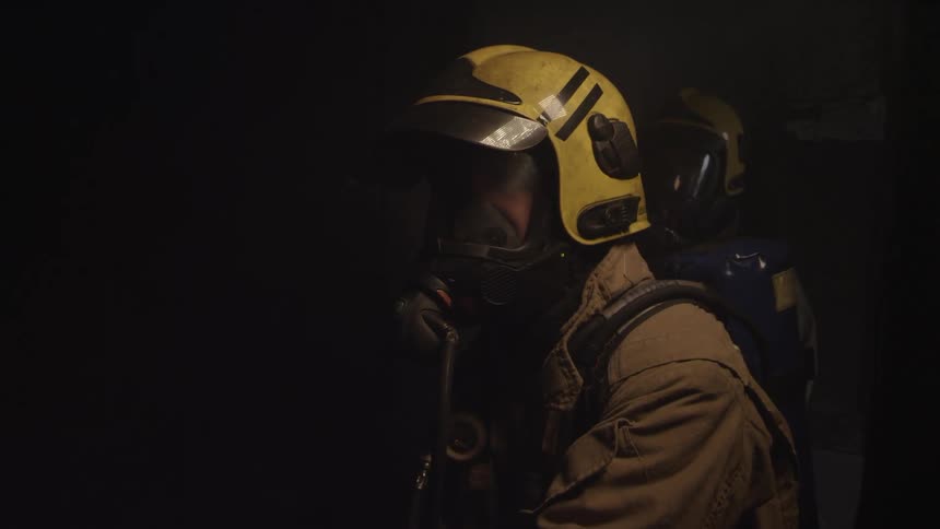 A firefighter turns the hose on and off
