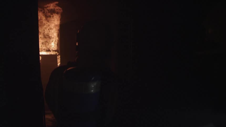 Firefighters approach a fire at night